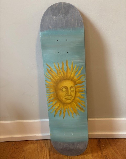 Painted sun design on a skateboard deck